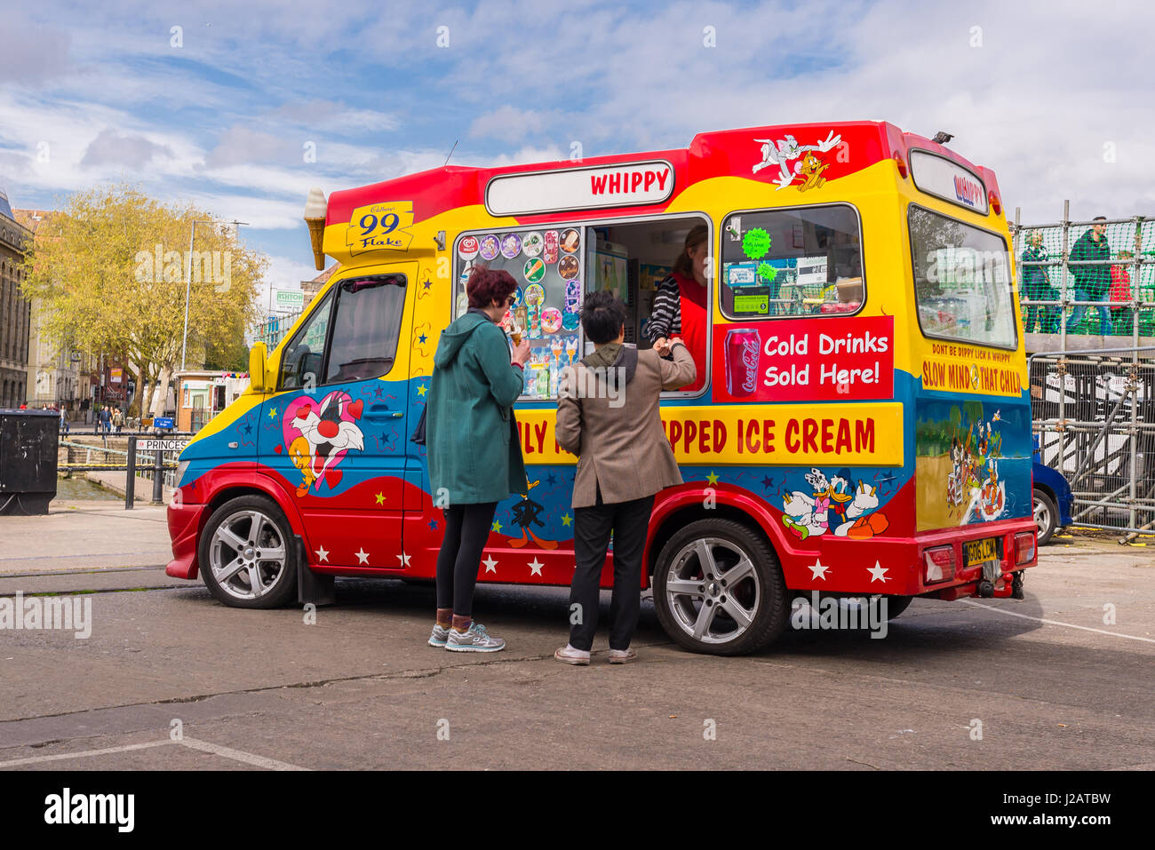 Zwei Kunden, die ein Eis von einem bunten Eiswagen kaufen Stockfoto