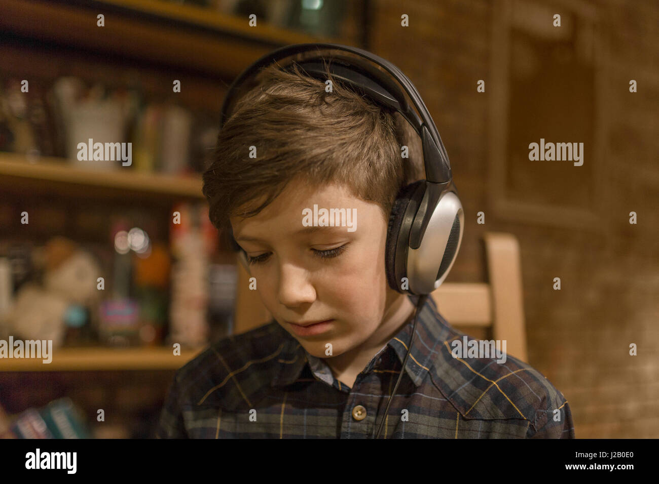 Junge Musik hören über Kopfhörer zu Hause Stockfoto