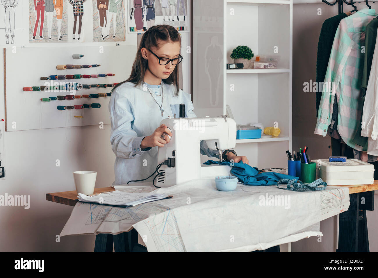 Weibliche Mode-Designer mit Nähmaschine im Design-studio Stockfoto