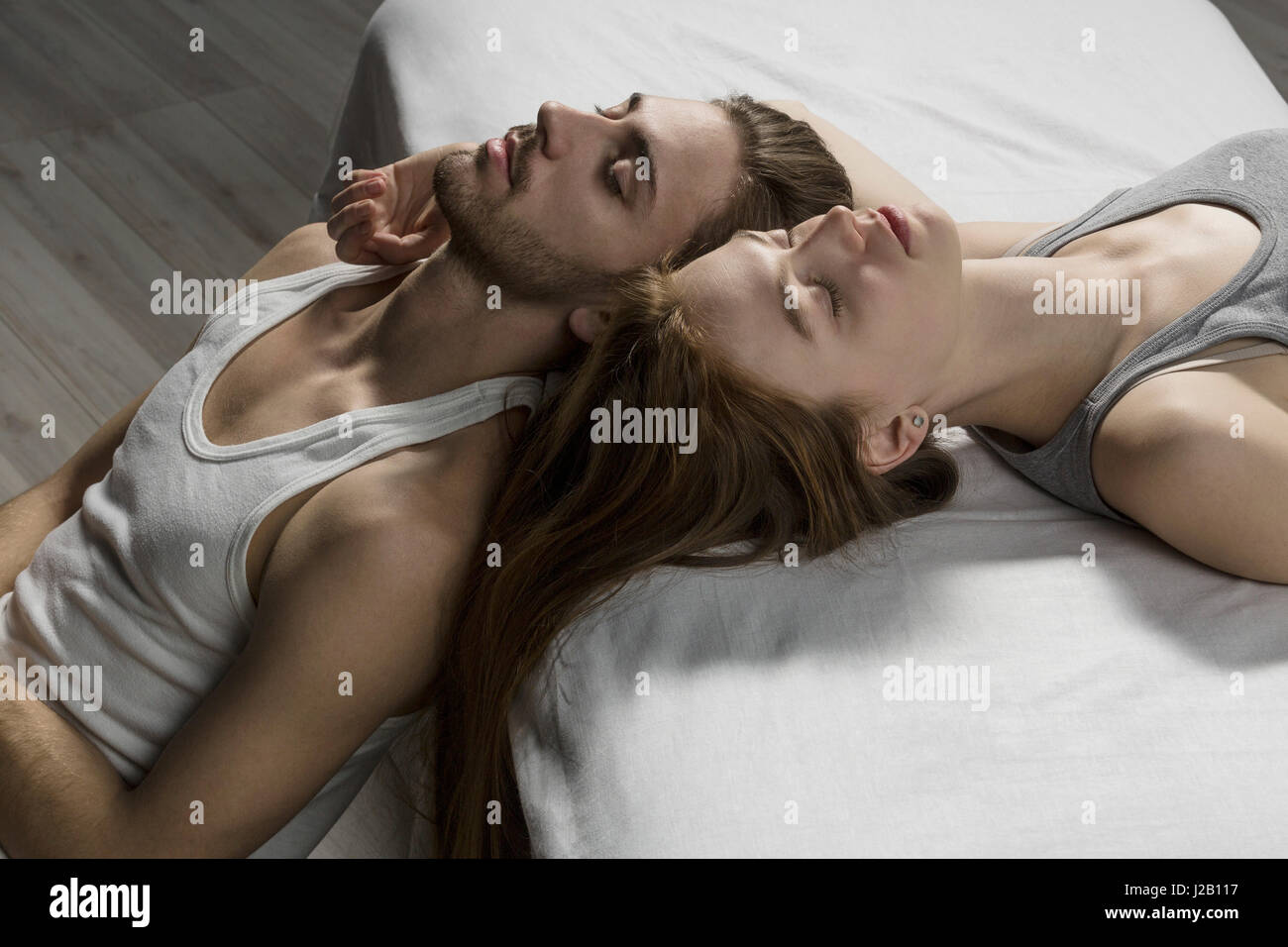 Erhöhte Ansicht des Paares mit geschlossenen Augen entspannend auf Bett Stockfoto