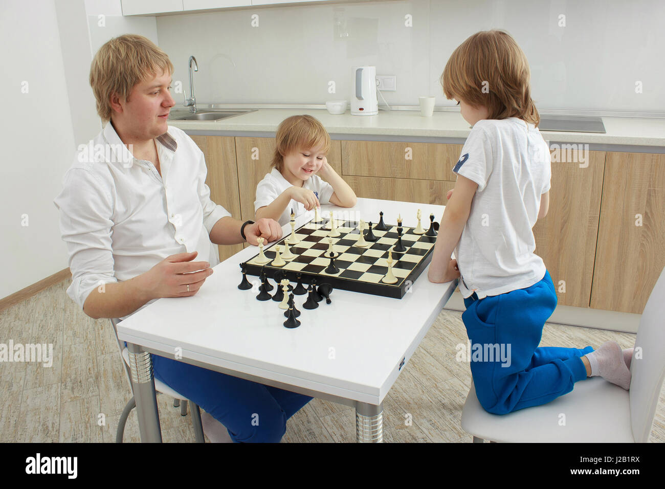 Familie spielt Schach auf einem Tisch zu Hause Stockfoto