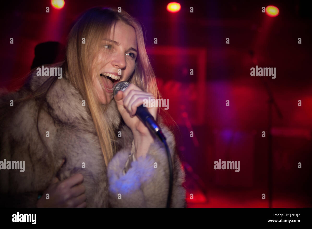 Junge Frau singen karaoke Stockfoto