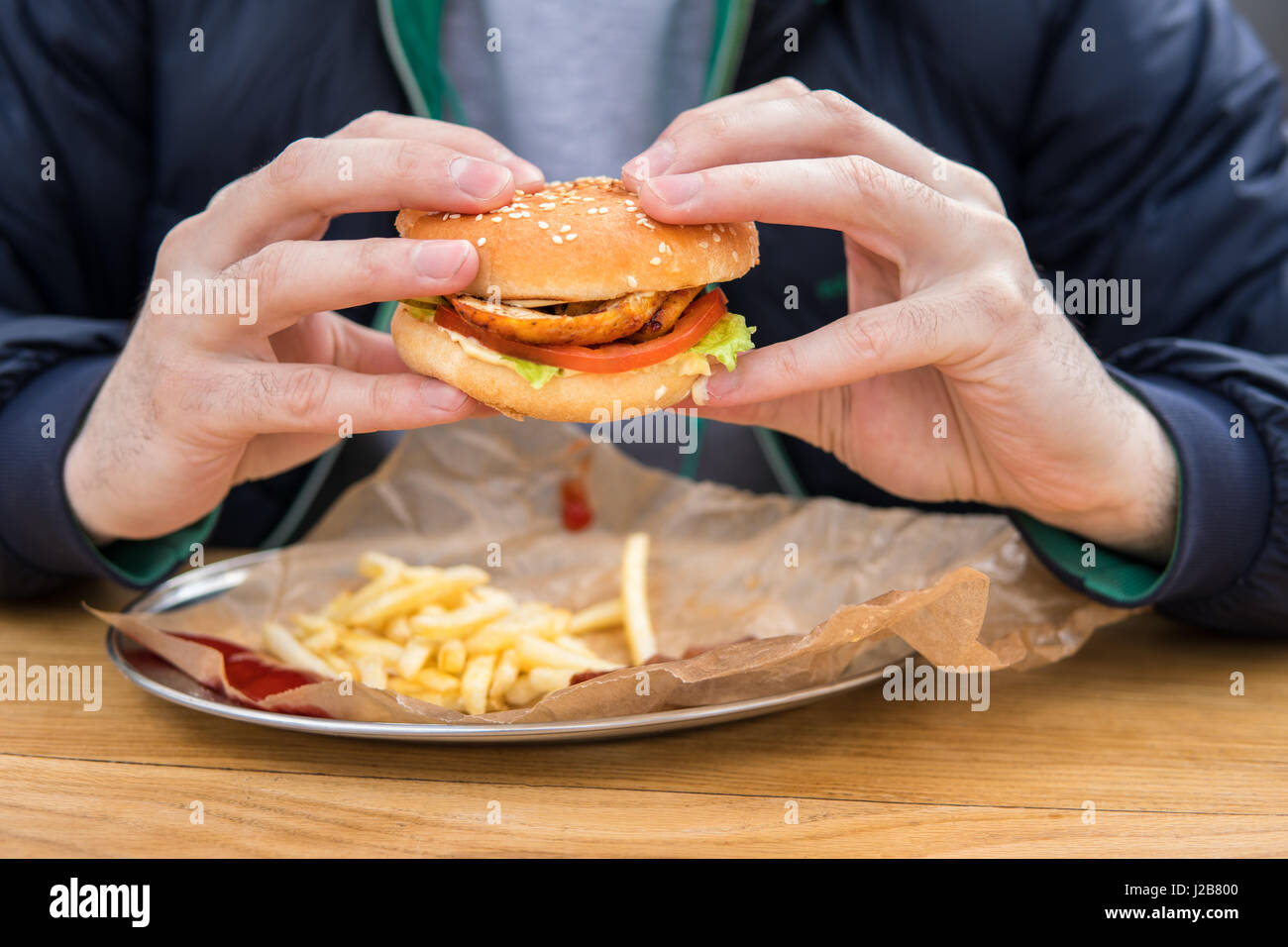 Nahaufnahme der Hände des Mannes mit amerikanischen Burger. Stockfoto