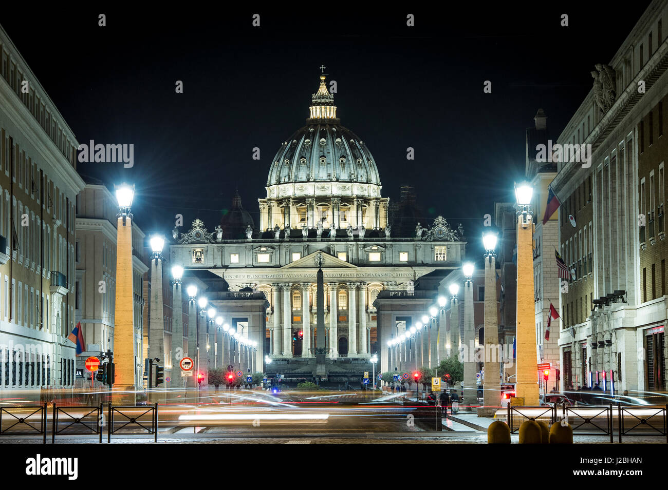 Blick auf den beleuchteten St. Peter Basilika, die Straße Via della Conciliazione und leichte Spuren von Autos in Rom, Italien Stockfoto