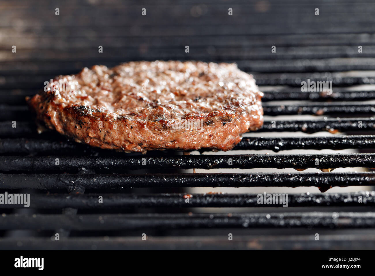 Beef Burger und Spachtel auf den Heißen lodernden BBQ Holzkohlegrill, Close-up Stockfoto