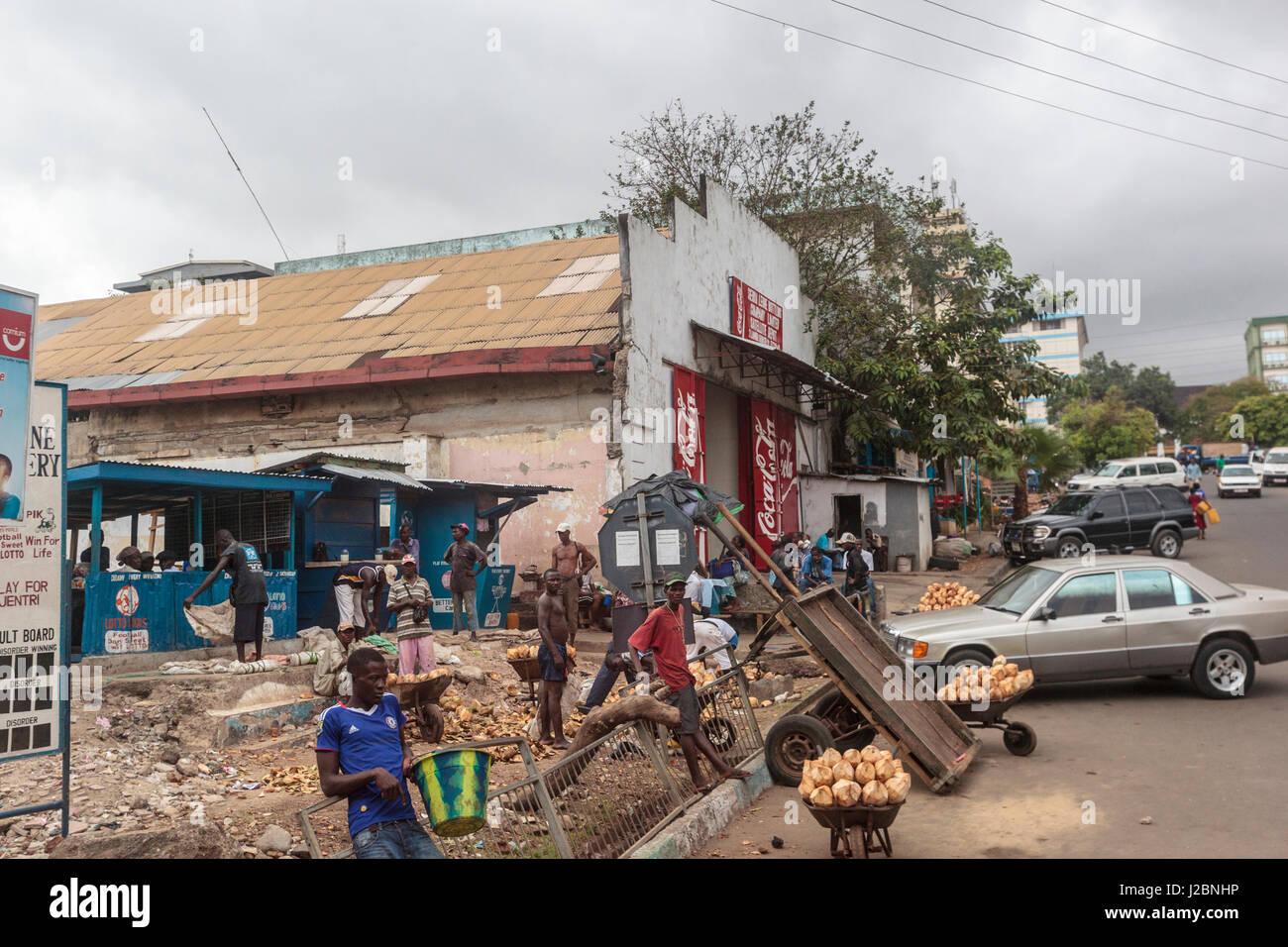 Afrika, Sierra Leone, Freetown. Männer am Straßenrand mit Kokosnüssen zu verkaufen. Stockfoto