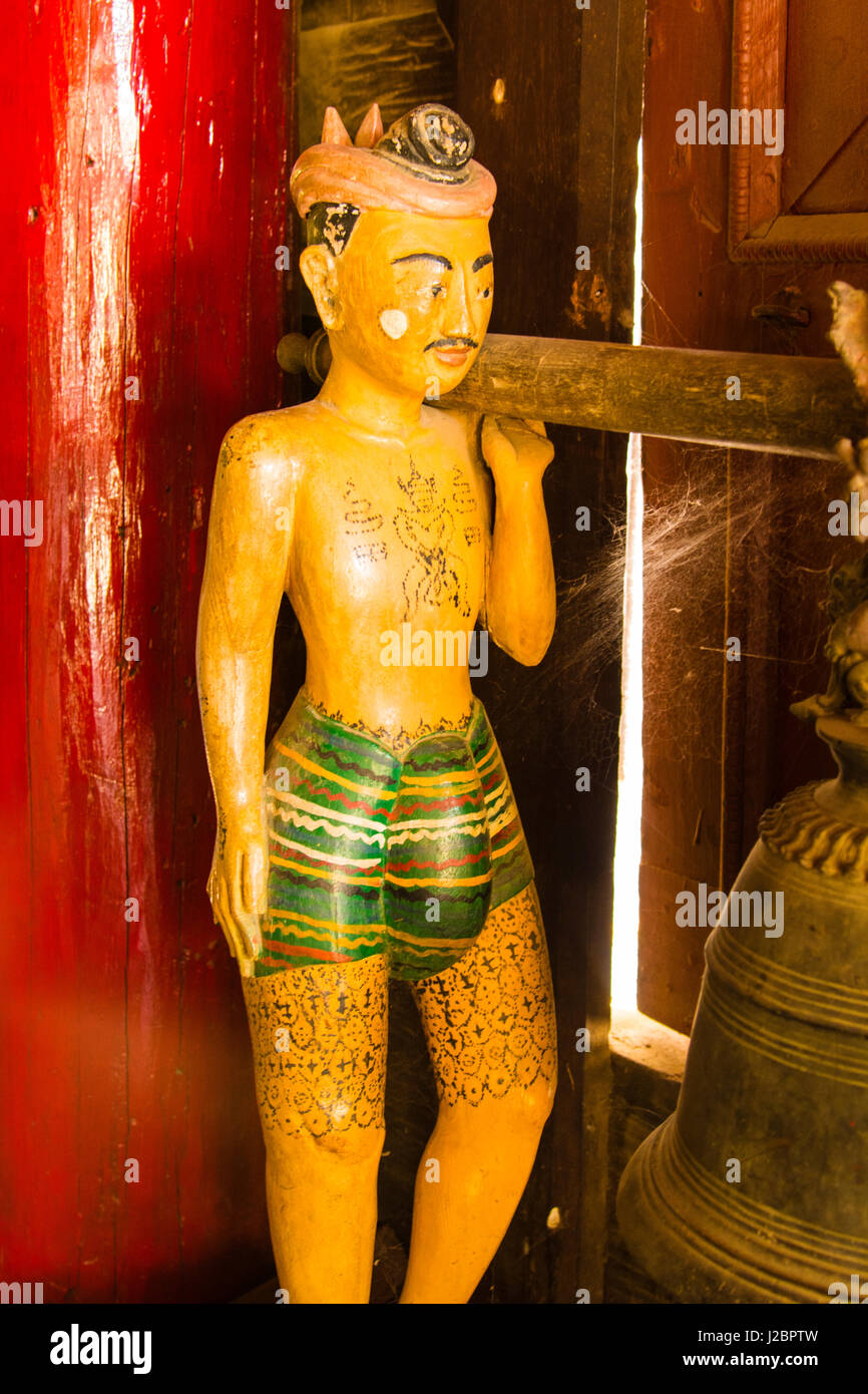 Myanmar. Mandalay. Geschnitzte Holzfigur in einem Teak Kloster anzeigen traditionellen birmanischen Tattoos. Stockfoto