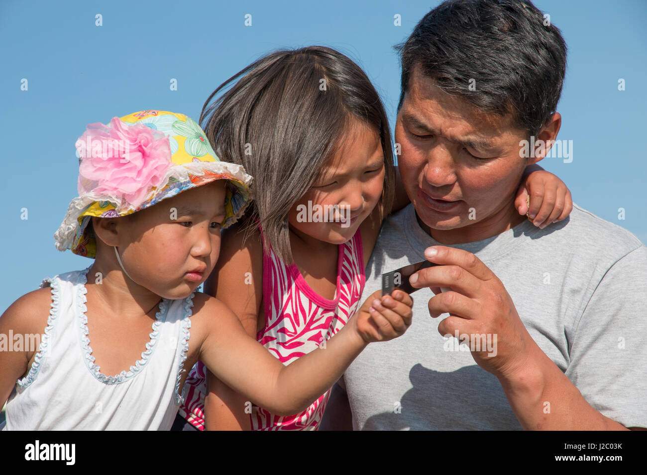 Asien, Mongolei, Hustai Nationalpark. 4 Jahre und sechs - jährige Töchter mit ihrem Vater, der Ranger, ein Foto von sich selbst zu prüfen ist. (Nur zur redaktionellen Verwendung) Stockfoto