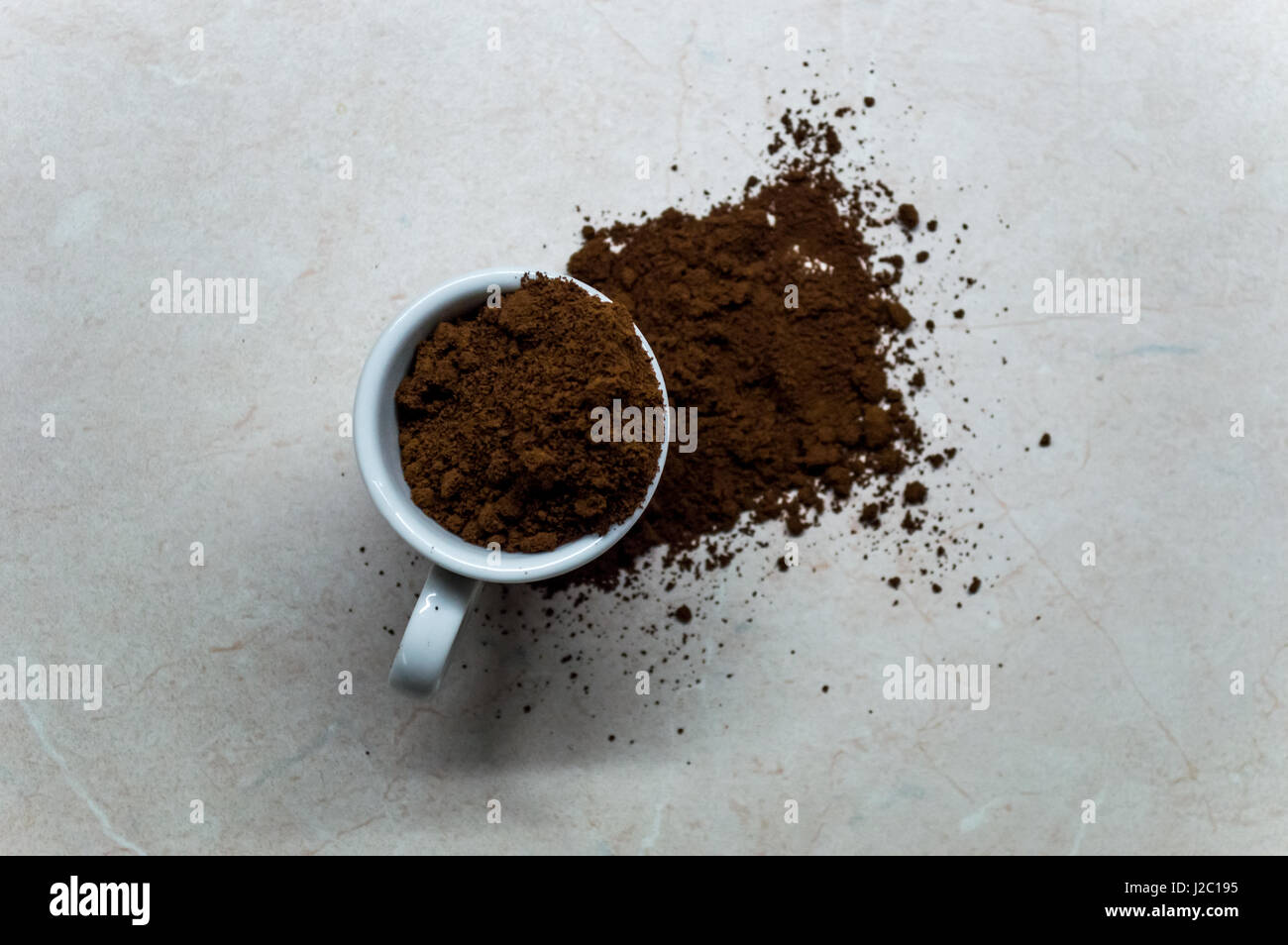 Kleinen Espressotasse mit gemahlenem Kaffee verschütten Stockfoto