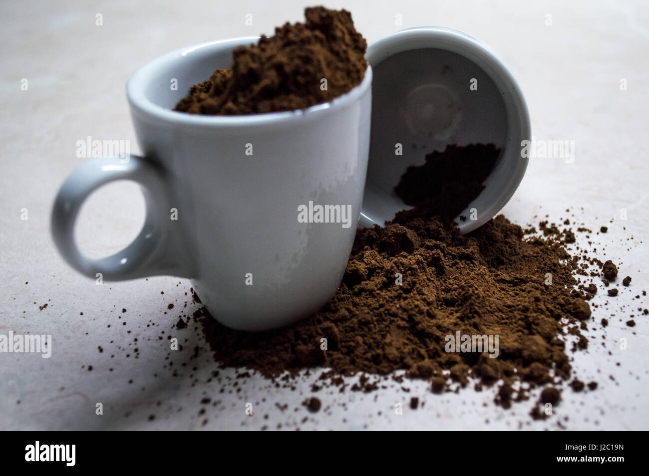 Kleinen Espressotasse mit gemahlenem Kaffee verschütten Stockfoto