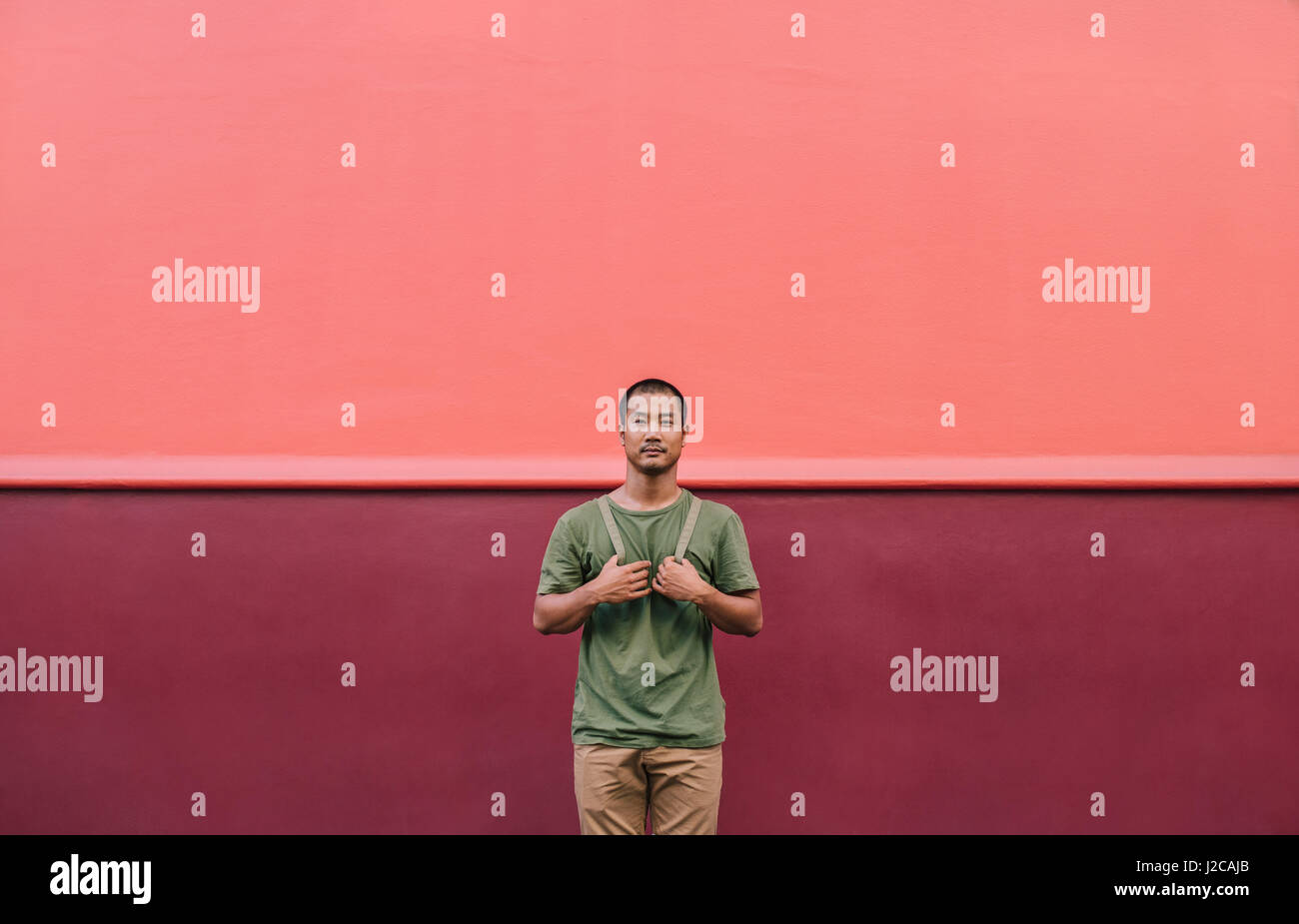 Coole jungen asiatischen Mann stehen auf einer bunten Stadtstraße Stockfoto