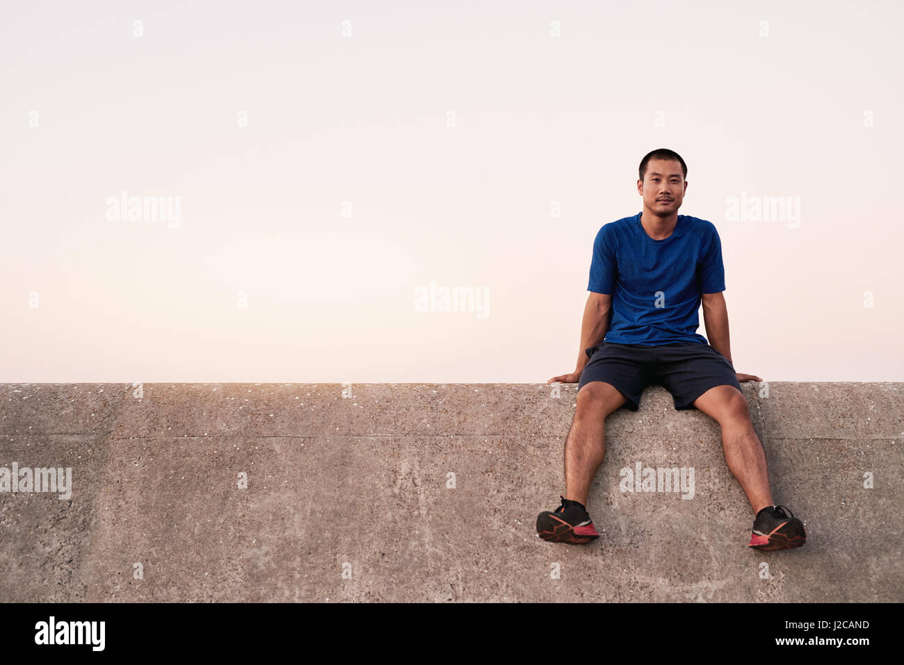 Jungen asiatische Mann eine Pause von einem Lauf zu passen Stockfoto