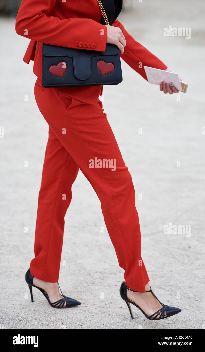 Frau im roten Hosenanzug mit Designer-Tasche, vertikale crop Stockfoto