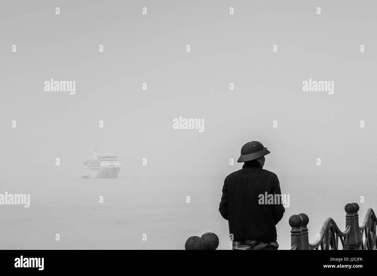 Vietnam, Halong City, Hafen, Schiff und Mann im militärischen Helm Stockfoto
