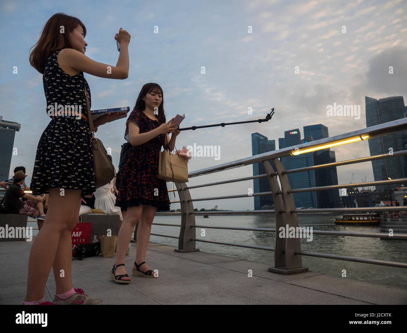 Touristen fotografieren mit Handykamera am Marina Bay, Singapur Stockfoto