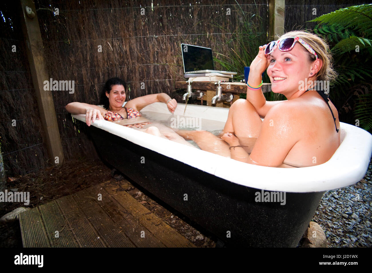 Die Scheune-Herberge entspannen Backpacker in einer einzigartigen alten altmodischen Badewanne im Freien, Abel Tasman National Park, Neuseeland. (HERR & PR) Stockfoto