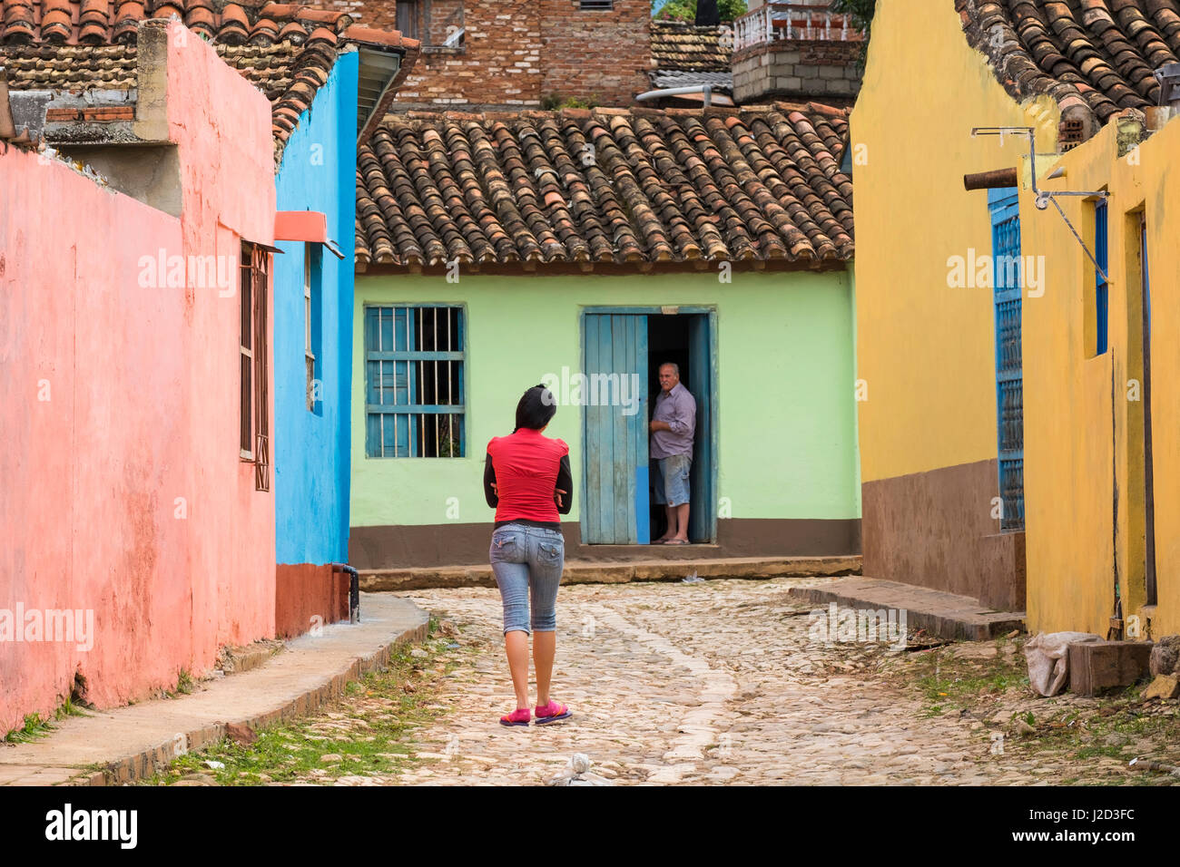 Kuba, Trinidad. Frau geht auf einer gepflasterten Gasse, einen Nachbarn zu besuchen. Stockfoto