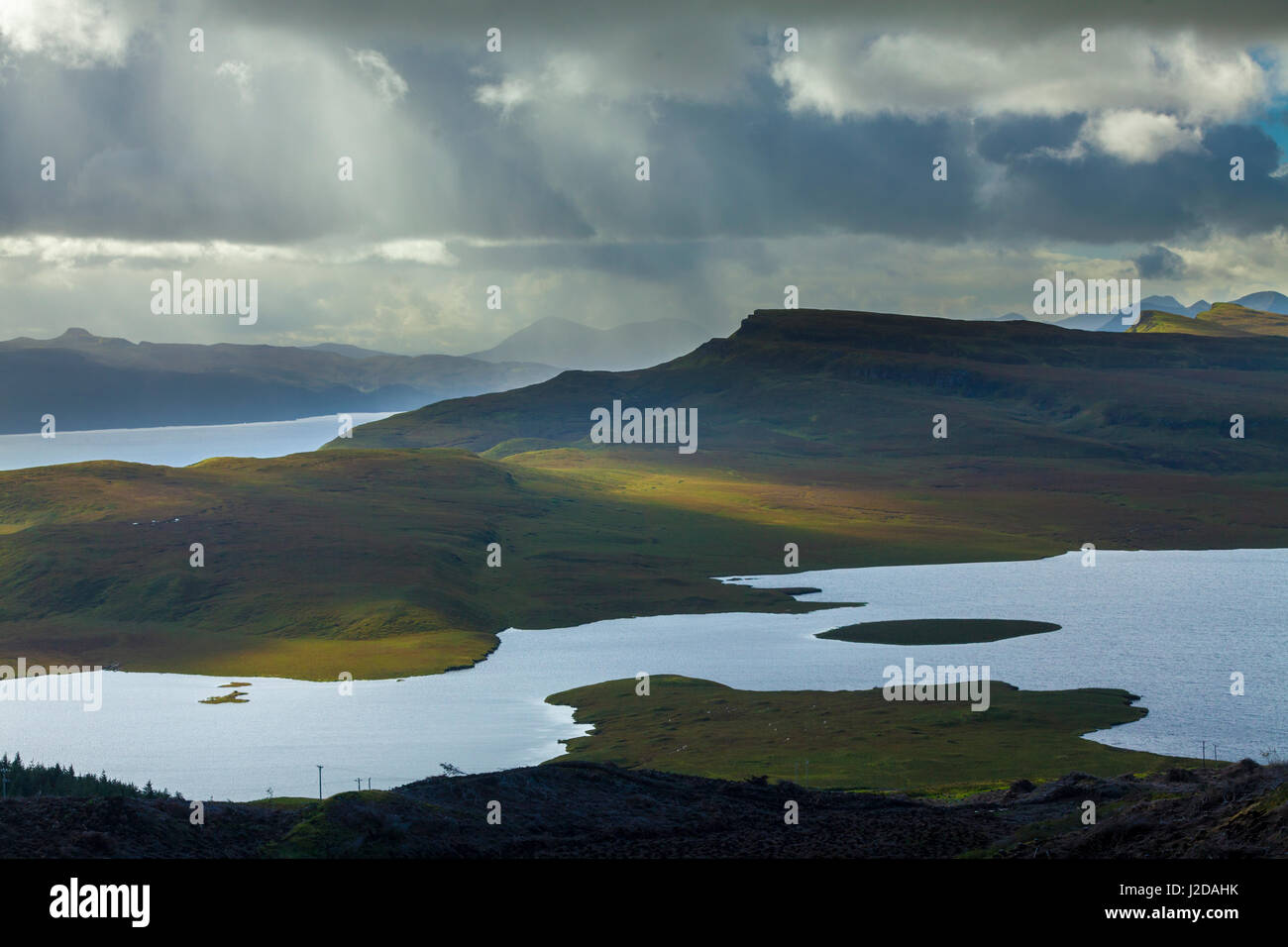scheint die Sonne durch die Wolken auf den Hügeln am Loch Leathan Stockfoto