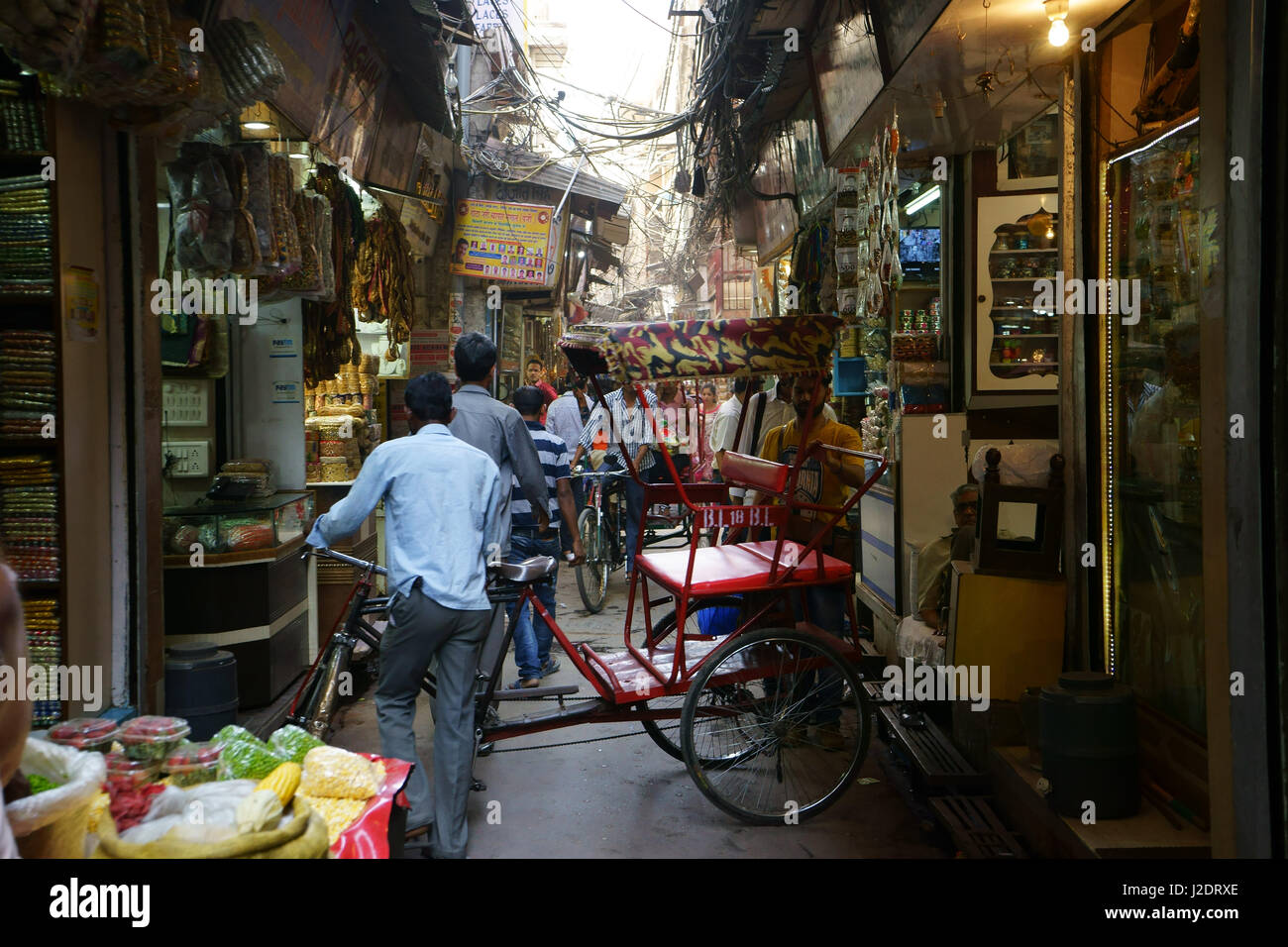 Schmale Straße mit kleinen Läden Gewürze in Old Delhi gefüllt mit Rikshas und Menschen, Indien Stockfoto