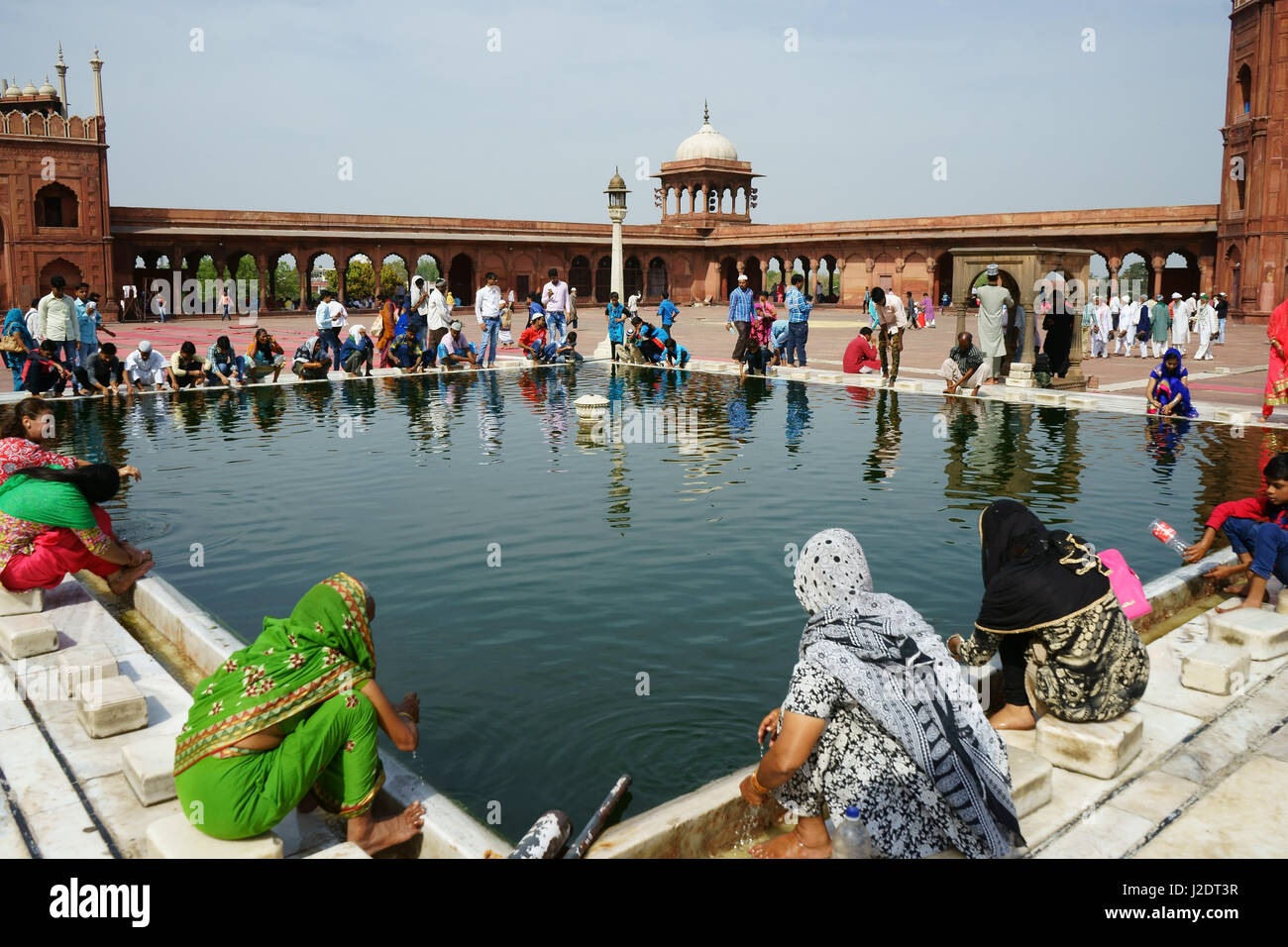 Muslimische Frauen und Männer nach dem Freitagsgebet waschen im Becken in Jama Masjid Moschee, Alt-Delhi, Indien Stockfoto