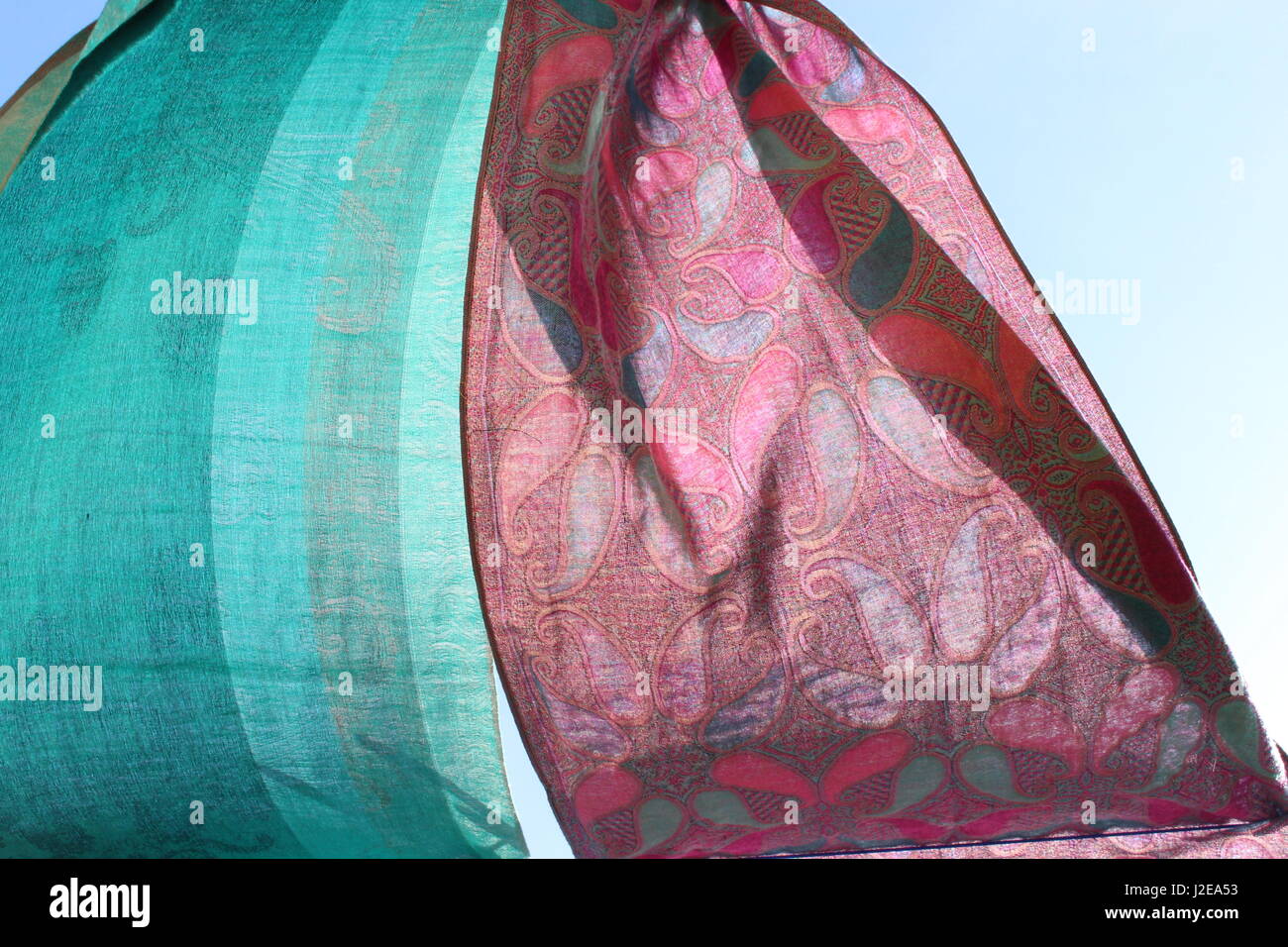 2 Seidentücher, Pink und Türkis, bläst der Wind gegen einen blauen Sommerhimmel Stockfoto