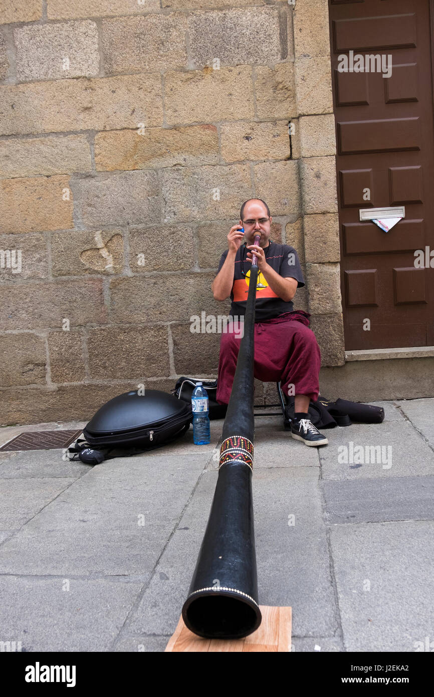Spanien, Santiago. Mann, asiatische Horn spielte und schütteln ein Krachmacher (nur zur redaktionellen Nutzung) Stockfoto
