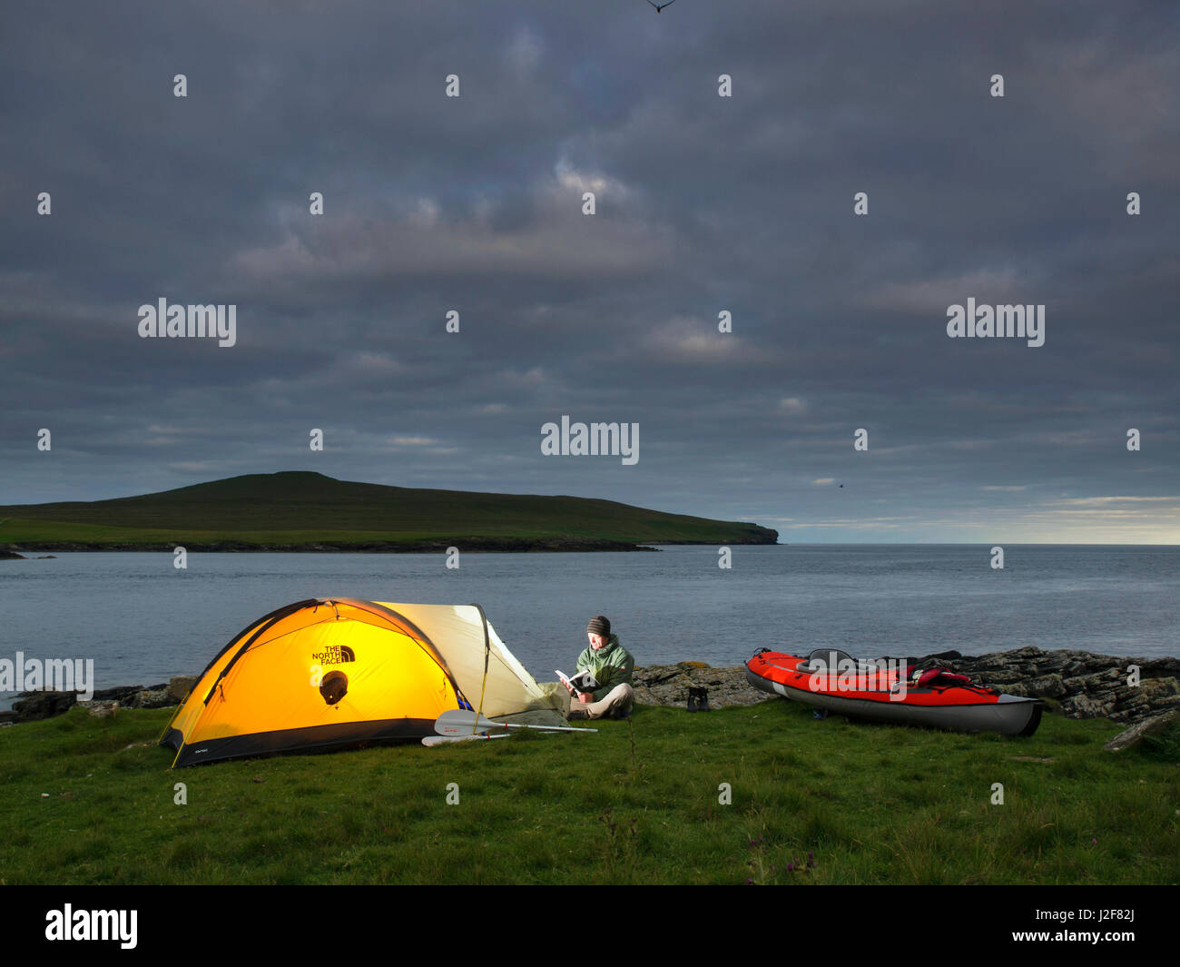 Mann mit Kajak in der Nähe der Tölpel Insel Noss auf den Shetland-Inseln, Schottland camping. Nordsee Stockfoto