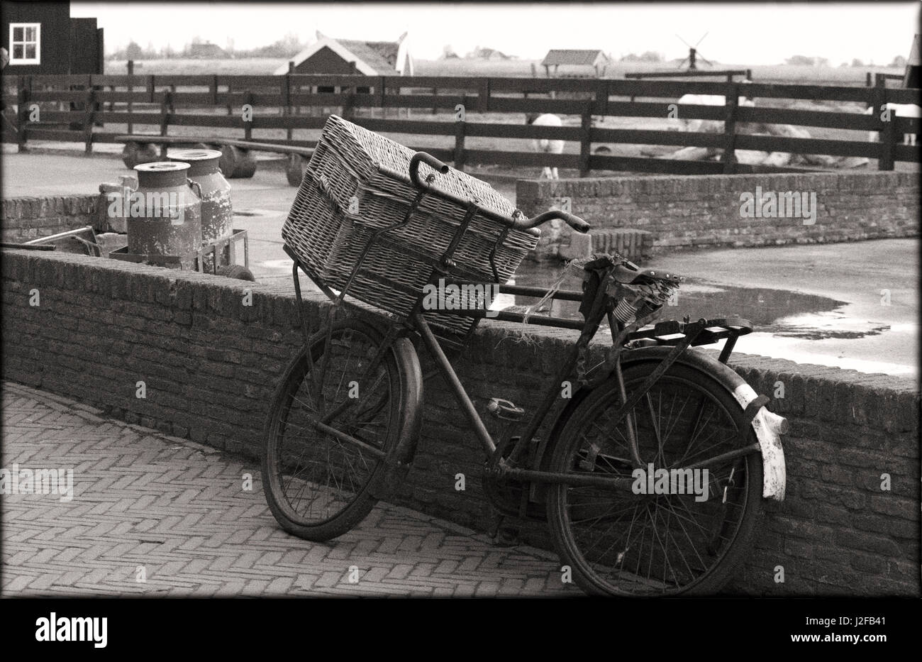 Eine altmodische Fahrrad mit Korb gelehnt wieder Mauer auf einem alten Bauernhof Stockfoto