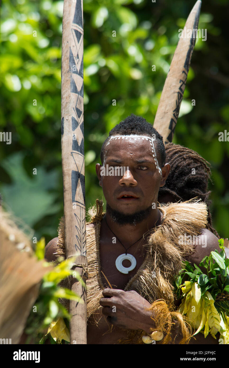 Melanesien, Salomon-Inseln, Santa Cruz Inselgruppe, Malo Insel. Dorf-Männer in native Kleidung Durchführung traditionellen Folklore Tanz mit Holzwaffen. Stockfoto