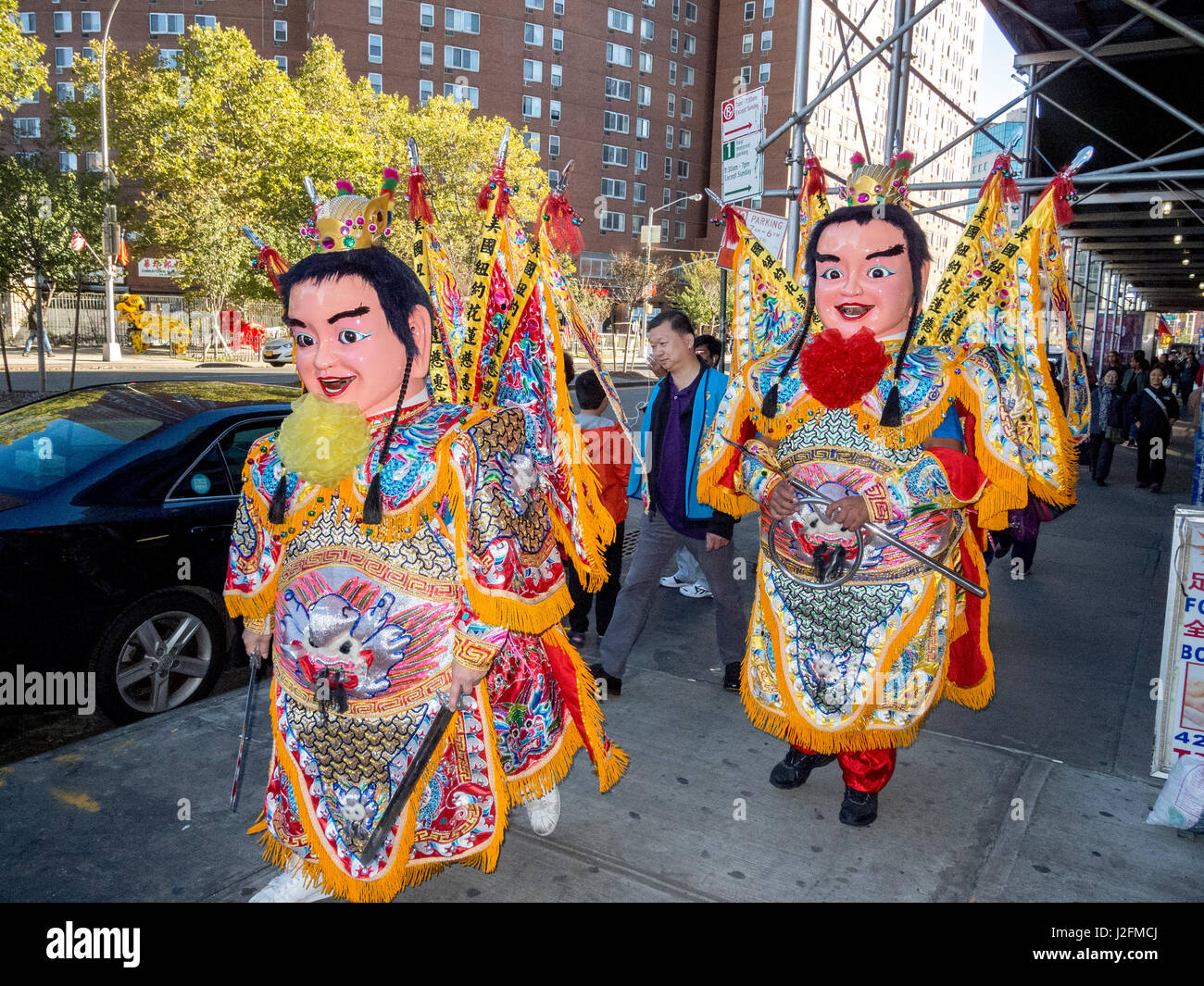 Maskierten und kostümierten Teilnehmer des Festivals kommen für die street Parade in New Yorks Chinatown. Stockfoto