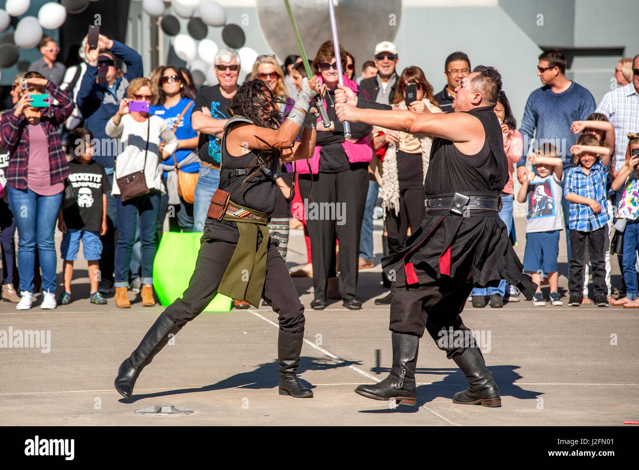 Akteure, die kostümierten Figuren aus dem futuristischen Science-Fiction-Film Star Wars Lichtschwerter überqueren, da das Publikum außerhalb der futuristischen Oakley-Hauptsitz in Foothill Ranch, CA beobachtet.  (Foto von Spencer Grant) Stockfoto