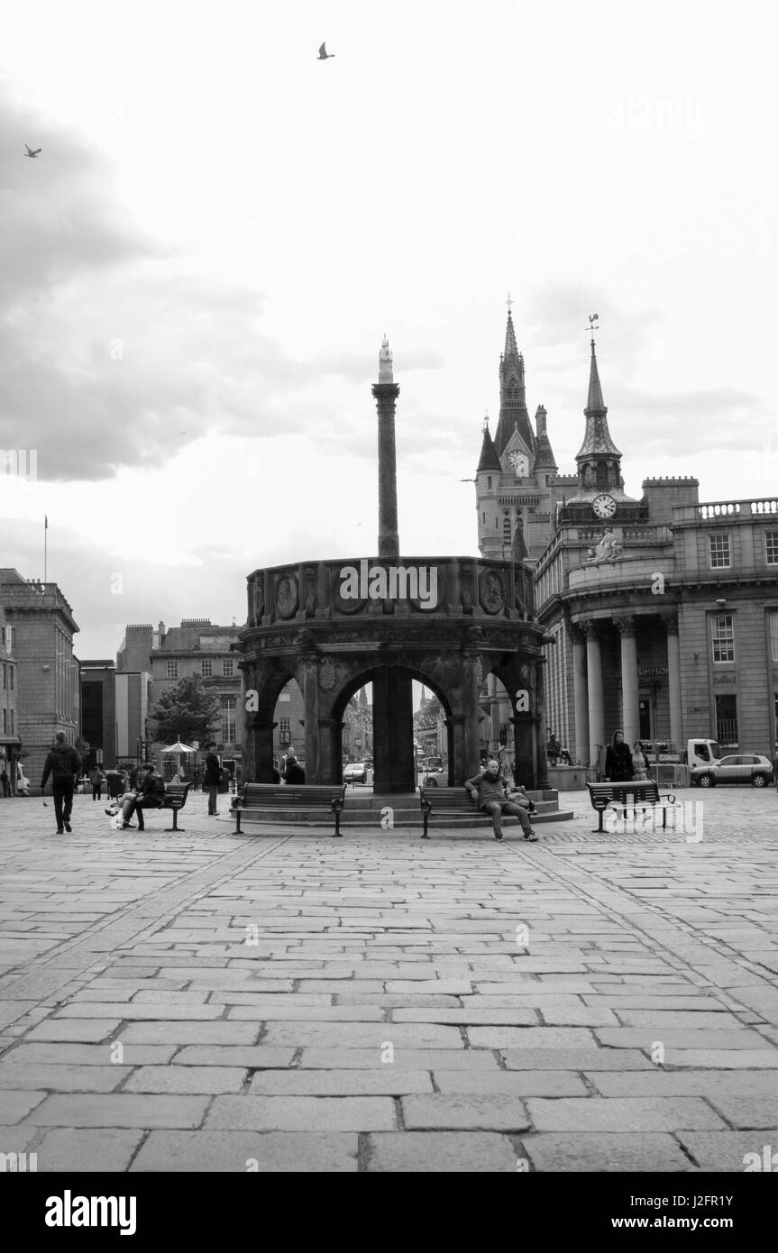 Castlegate, Aberdeen Stadtzentrum, die Heimat der britischen Öl-Industrie.  Die Menschen entspannen auf den Bänken auf der gepflasterten Straße malt einer traditionellen britischen Szene. Stockfoto