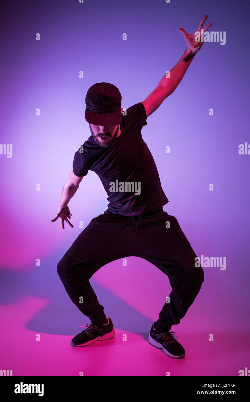Die Silhouette von einem jungen hip Hop männlichen Pause Tänzer tanzen auf farbigen Hintergrund Stockfoto
