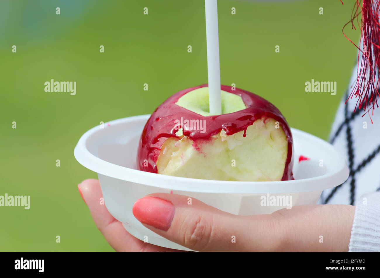 Angebissene Apfel Glasur in eine Schüssel geben und die Hände. Stockfoto