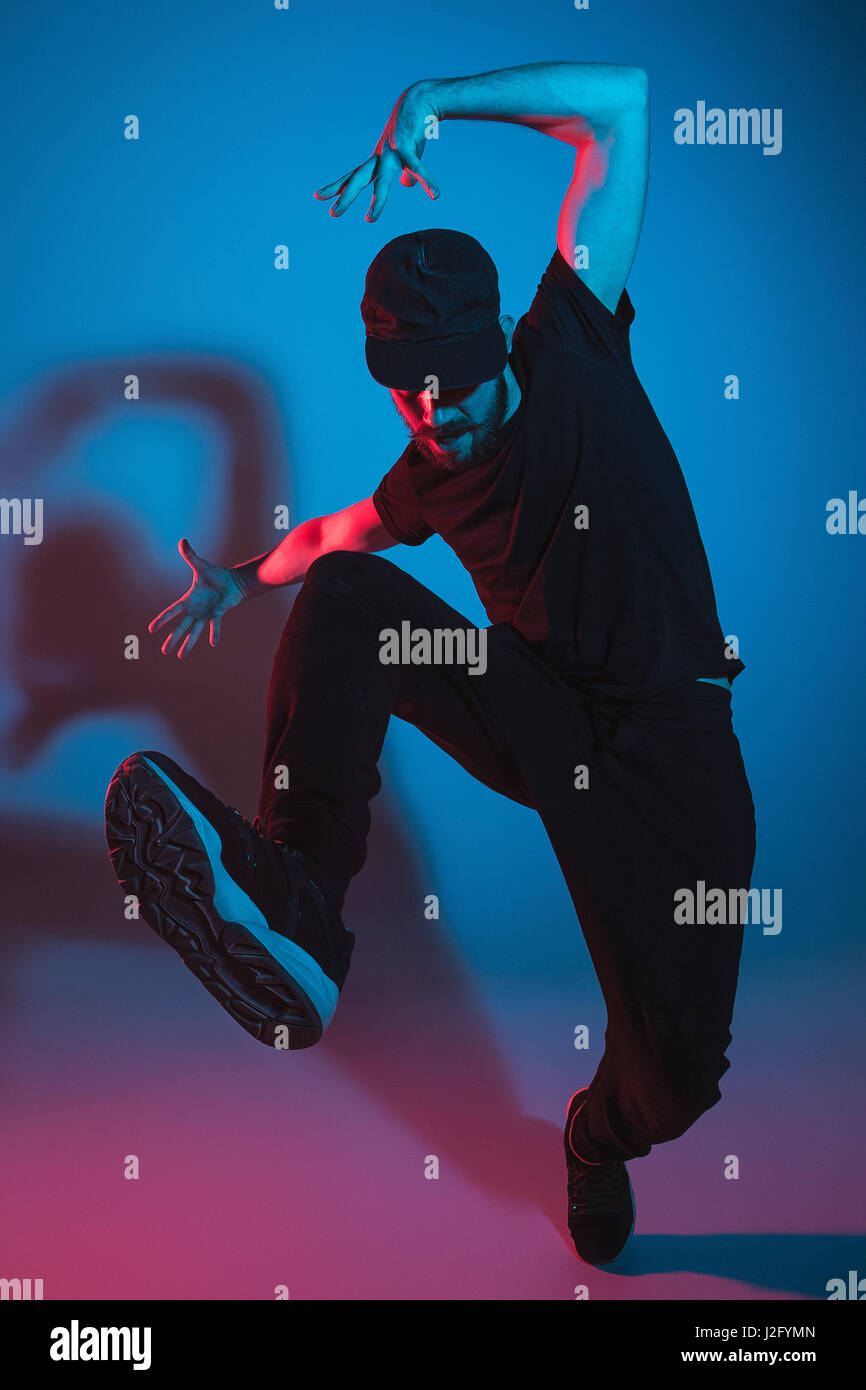 Die Silhouette von einem jungen hip Hop männlichen Pause Tänzer tanzen auf farbigen Hintergrund Stockfoto
