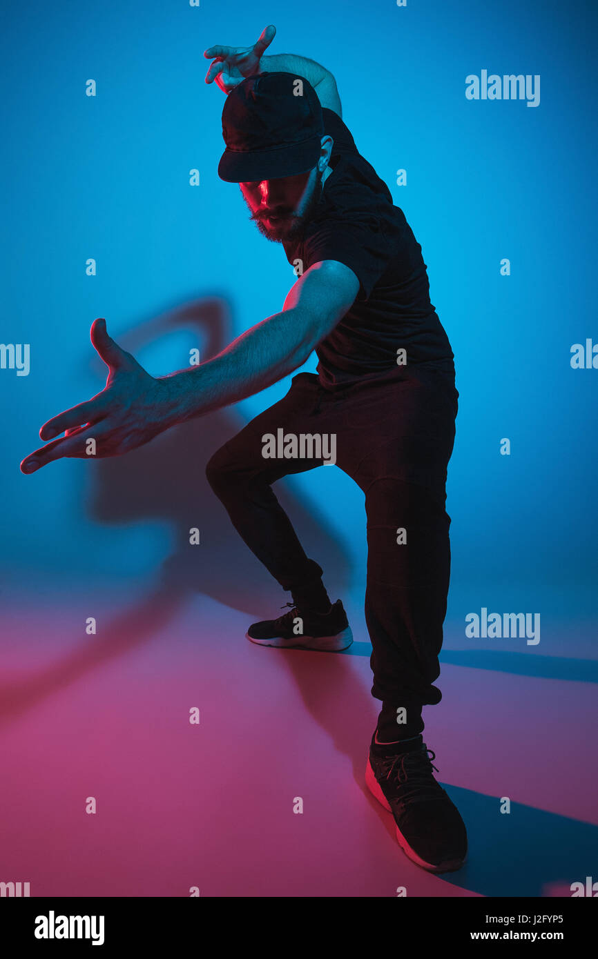Die Silhouette von einem jungen hip Hop männlichen Pause Tänzer tanzen auf farbigen Hintergrund Stockfoto