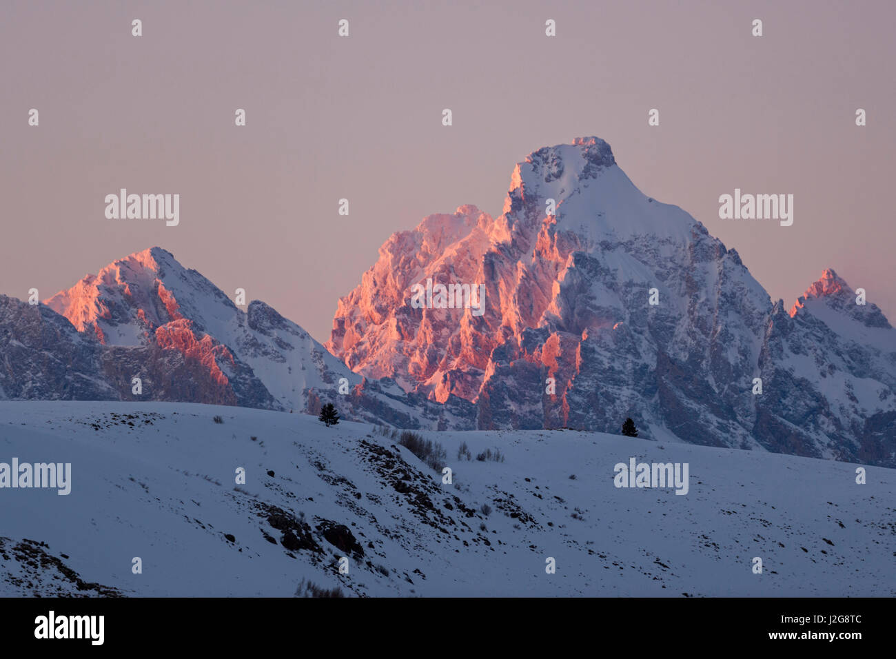 Grand Teton Range im Winter, im letzten Abendlicht bedeckt Schnee, bei Sonnenuntergang, Grand-Teton-Nationalpark, Wyoming, USA. Stockfoto