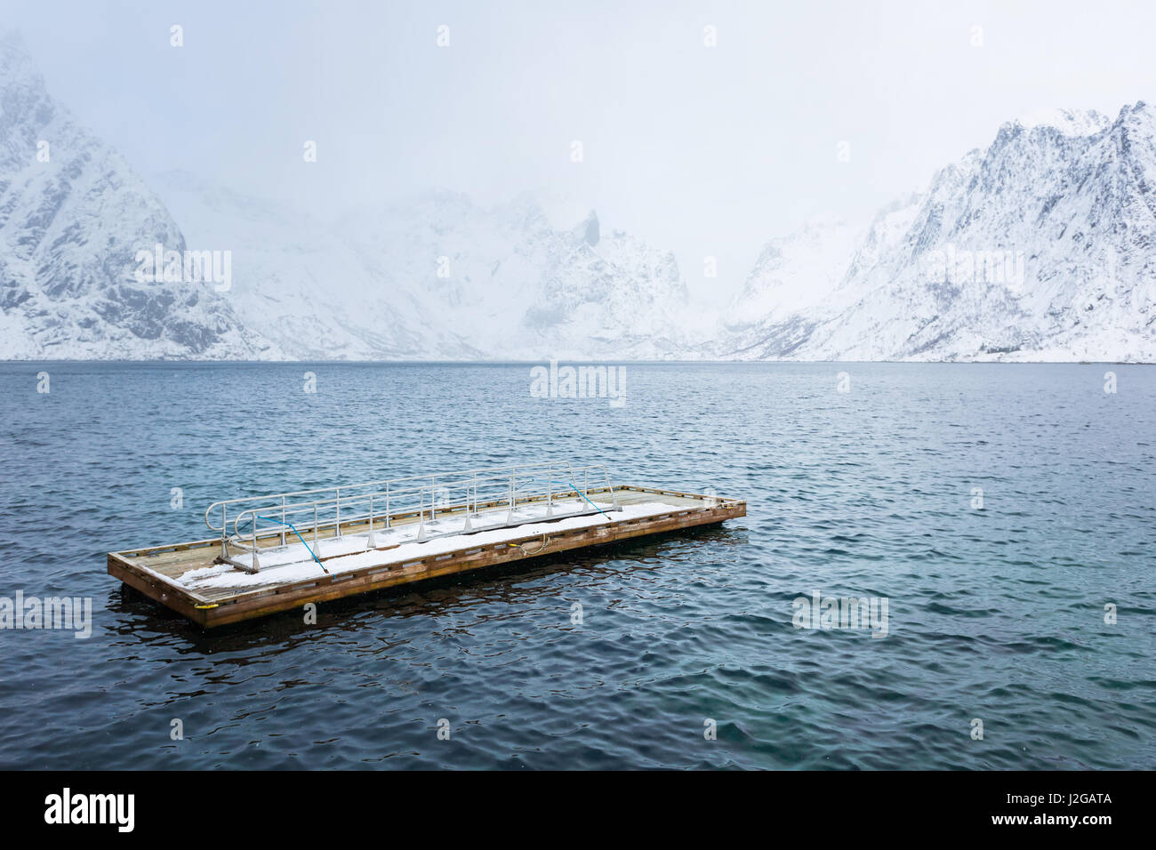 Hölzernen Schwimmsteg im Meer vor dem Hintergrund der Schnee Berge der Lofoten Stockfoto