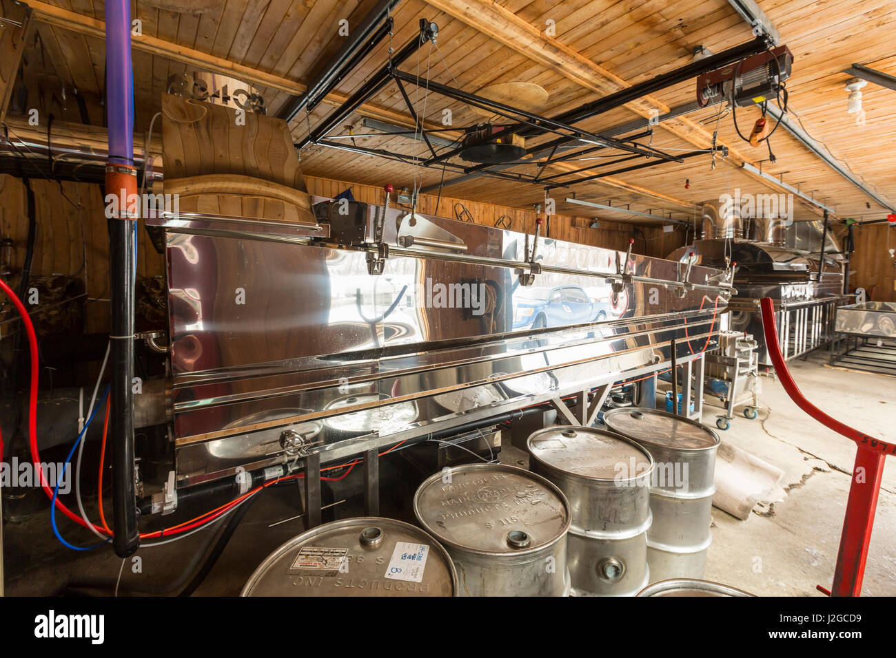 Edelstahl-Fässer, die verwendet werden, zu lagern und transportieren Sie Ahornsirup sitzen vor einem der SAP-Kessel am LaRiviere Familie Sirup Vorgang in Big Six Township, Maine. Stockfoto