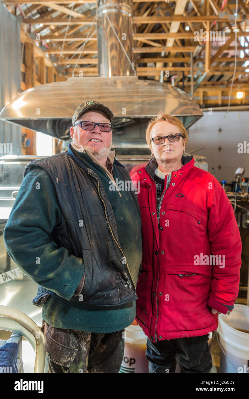 Lili und Mario Giroux vor dem SAP-Kessel in ihre Sugarhouse in Big Six Township, Maine. (MR) Stockfoto