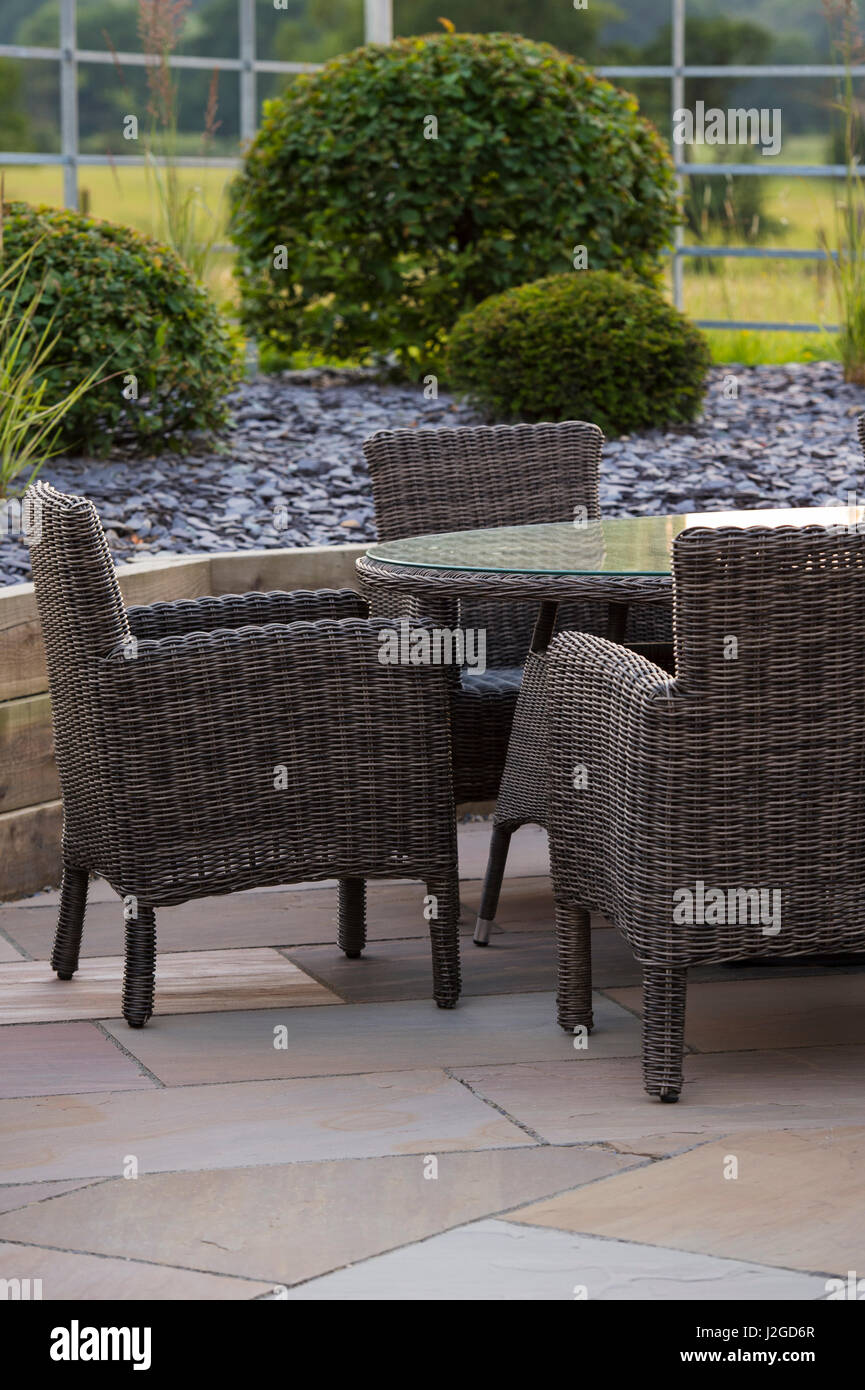 Schön, privat, modern gestalteten, Garten, Yorkshire, England, UK - Schanigarten (Patio-Möbel) durch erhöhte Grenze & topiary Sträuche. Stockfoto