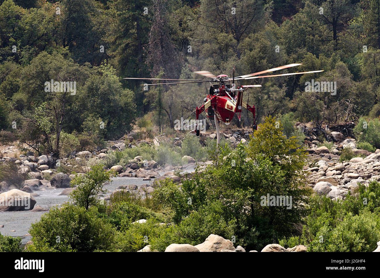 USA, California, El Portal, S-64 Skycrane Hubschrauber nehmen Wasser aus Merced River gegen Waldbrand Stockfoto