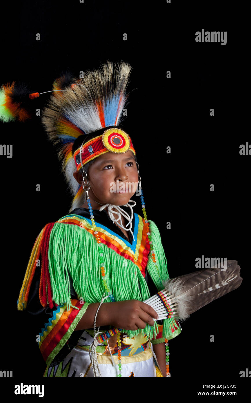 10 Jahre alte Thomas Tom (Temoke-Shoshone) in bunten Rasen Tänzerin Outfit und Roach Kopfschmuck mit schwarzem Hintergrund gekleidet Stockfoto