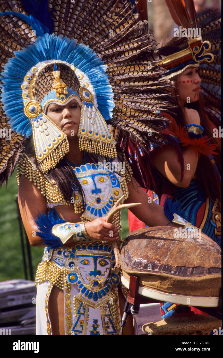 Traditionell gekleidete aztekischen Frau spielt eine große Schildpatt-Rassel, die langsam hin und her geschaukelt wird. Stockfoto