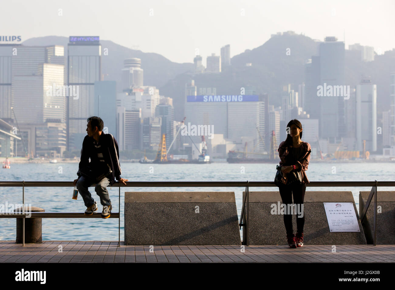 HONG KONG - 26 Februar: Junge Frau und Mann an der Tsim Sha Tsui Promenade am 26. Februar 2014 in Hongkong ruhen. Stockfoto