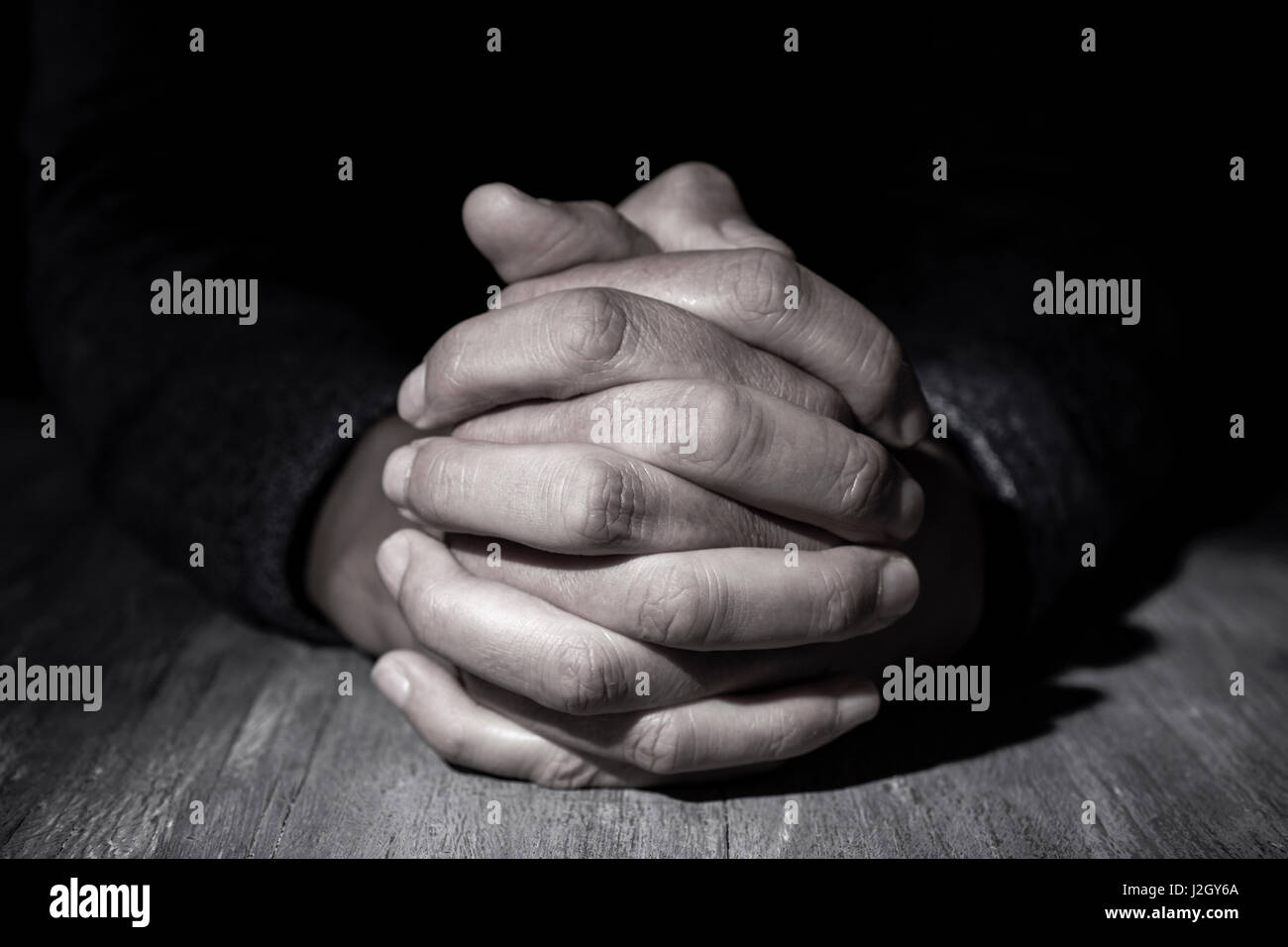 Nahaufnahme von den Händen der kaukasischen Jüngling mit seiner Hände auf einem Holztisch Stockfoto