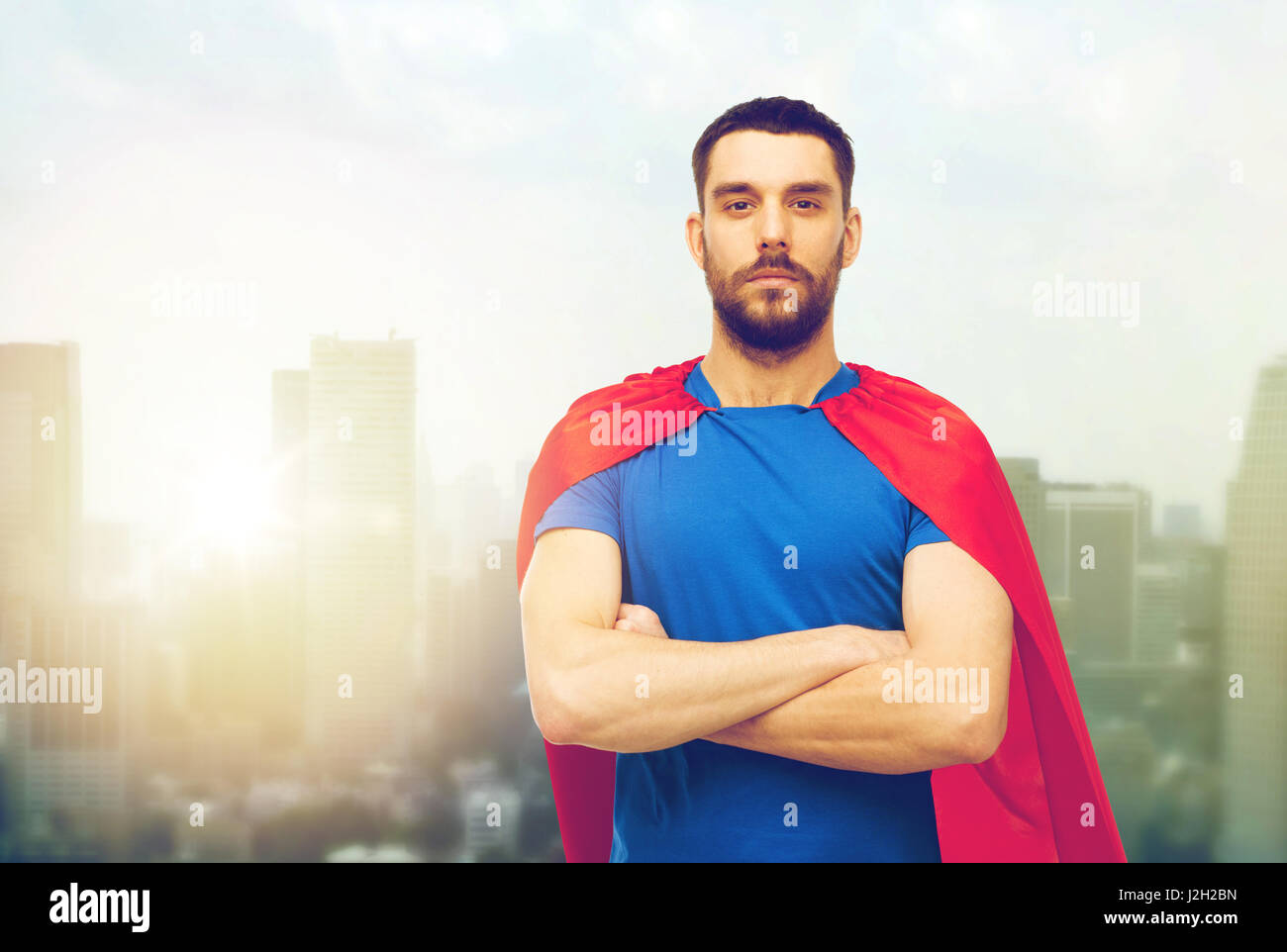 Mann in rote Superheld Kap über Stadt Hintergrund Stockfoto
