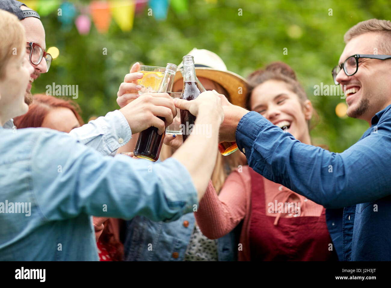 Glückliche Freunde klirrende Gläser im Sommergarten Stockfoto