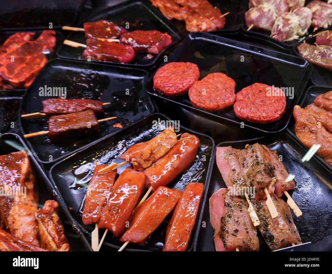 Eingelegtes Fleisch zum Grillen in einem Theken-Display in einem  Supermarkt. Fleisch beim Metzger Stockfotografie - Alamy