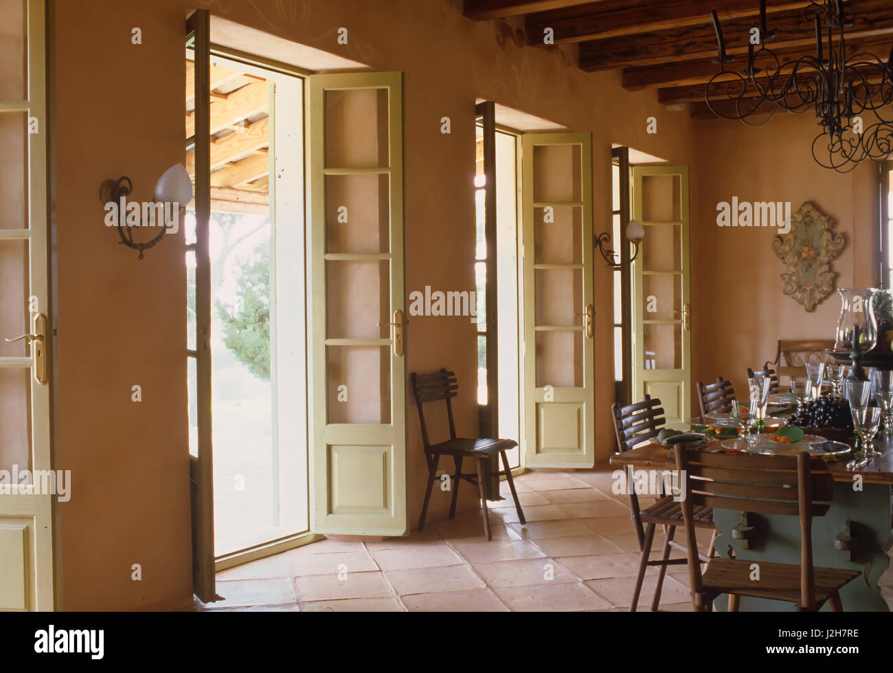 Tisch und Stühle mit französischen Türen öffnen Stockfoto